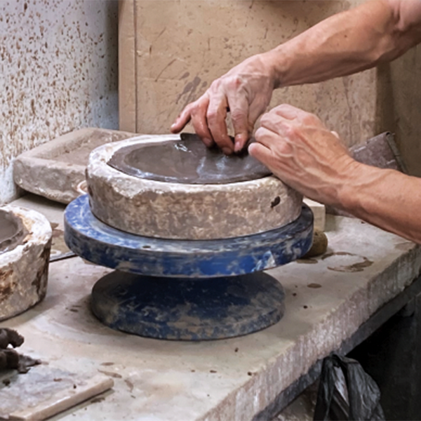 1 Luis Cortez adding a coil to the edge of a slab-molded form before joining the two halves.