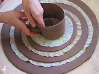 Score the bottom edge of the smallest bowl's wall and the edge of its base, leaving it in place. Apply slip and join.