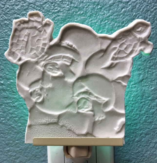 4 Trimmed section of my lithophane image, supported by bracket and wall plug and plugged into an outlet. Note: the image is recessed.