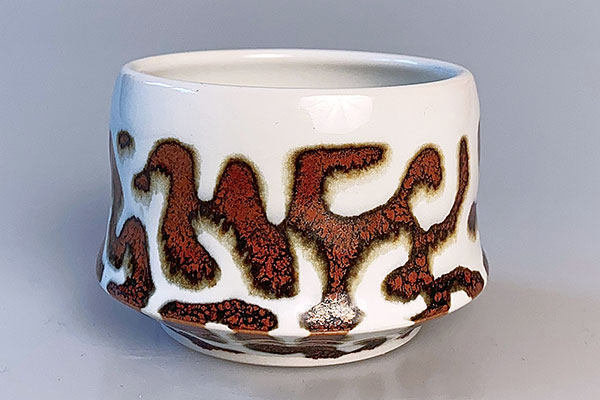 24 Lori Piecyk’s Red Iron Pattern Cup, 3 in. (8 cm) in height, porcelain, fired to cone 10 in reduction.