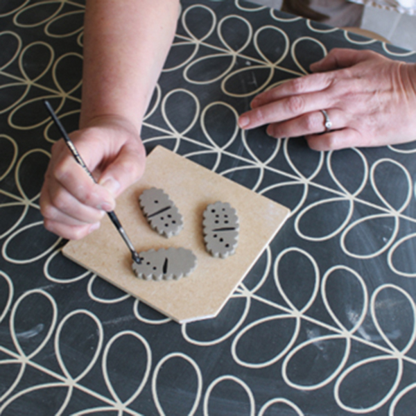 2 Brush oxides onto cut tiles to create dots and stripes.