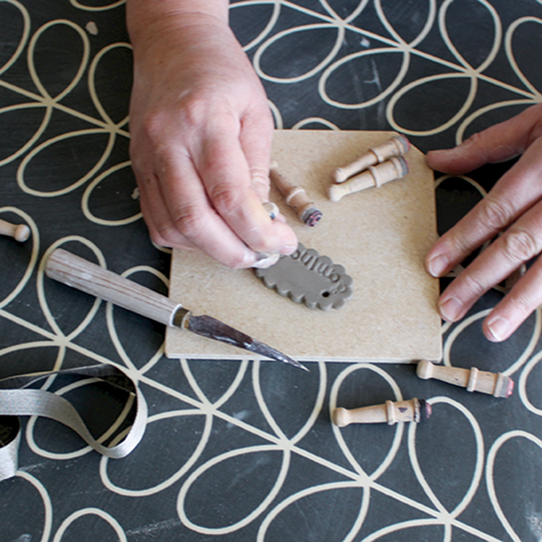 3 Create a domino tag for the storage box using stamps and a hole cutter.