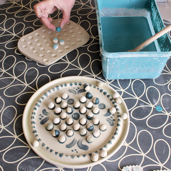 9 Glaze the game base, then glaze only half of each marble.