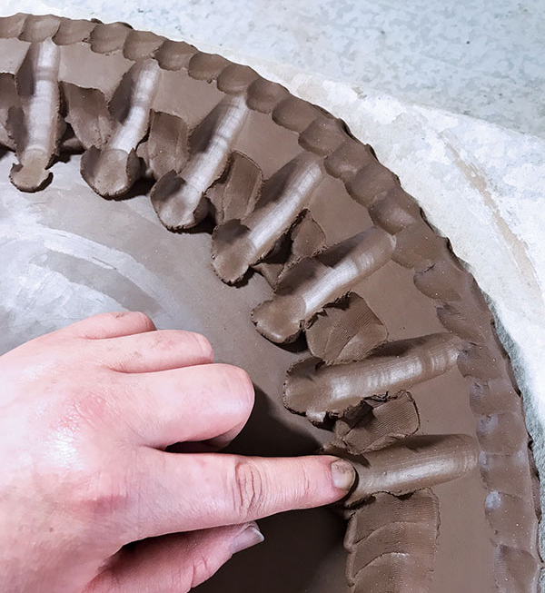 5 Drag the clay with your index finger in increments to create a pattern. 