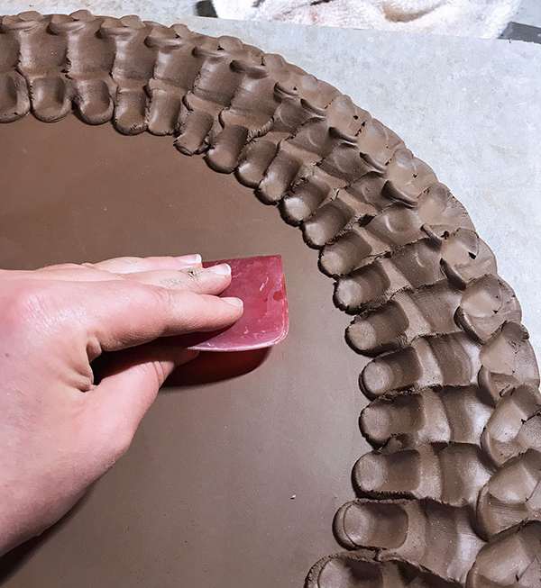 8 Use a Mudtools red rubber rib to refine the center of the plate.