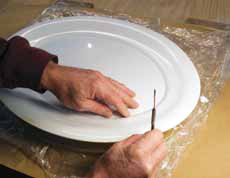 4 Once you have the correct alignment, press the platter evenly on all sides to imprint the tray’s oval foot in the clay.