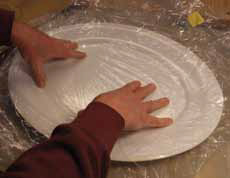 6 Smooth the rim with your fingers then with tapered tip of a Popsicle stick. Lay a piece of plastic in the platter form.