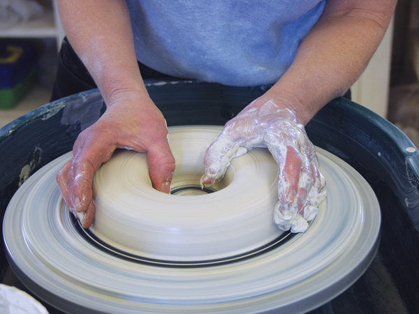 1 Center and spread your clay out into a mound about 8 inches across, then open up the center all the way to the bat.