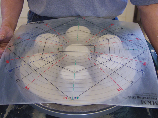 3 Arrange the cups on the underside of a rolled and pre-cut slab. Use a decorating disk to space them evenly.