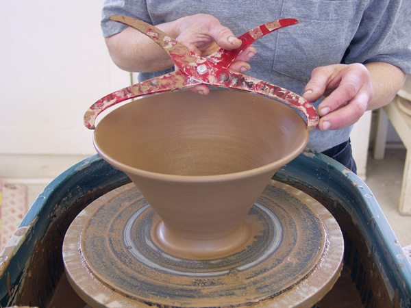 4 Throw the lid upside-down as a tall, narrow bowl. Flare the rim and make it a bit larger than the measurement. 