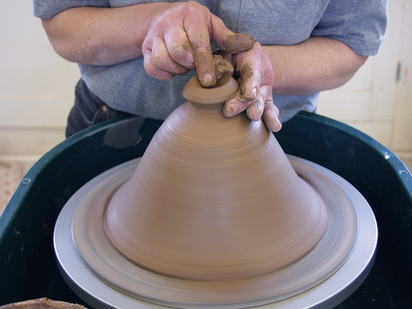 5 Center the lid right side up when it is leather hard, trim off any excess clay, and add a knob.