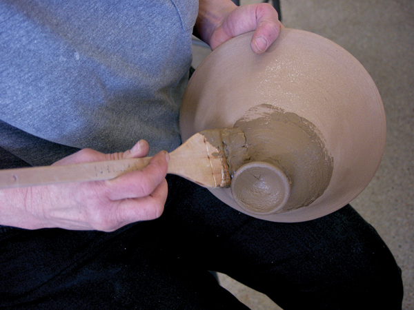 8 To burnish the bone-dry tagine, brush a layer of mica slip onto part of the pot. Don’t worry if it goes on lumpy.