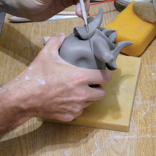 6 Attach a tapered coil to the base of the upside-down mug. 