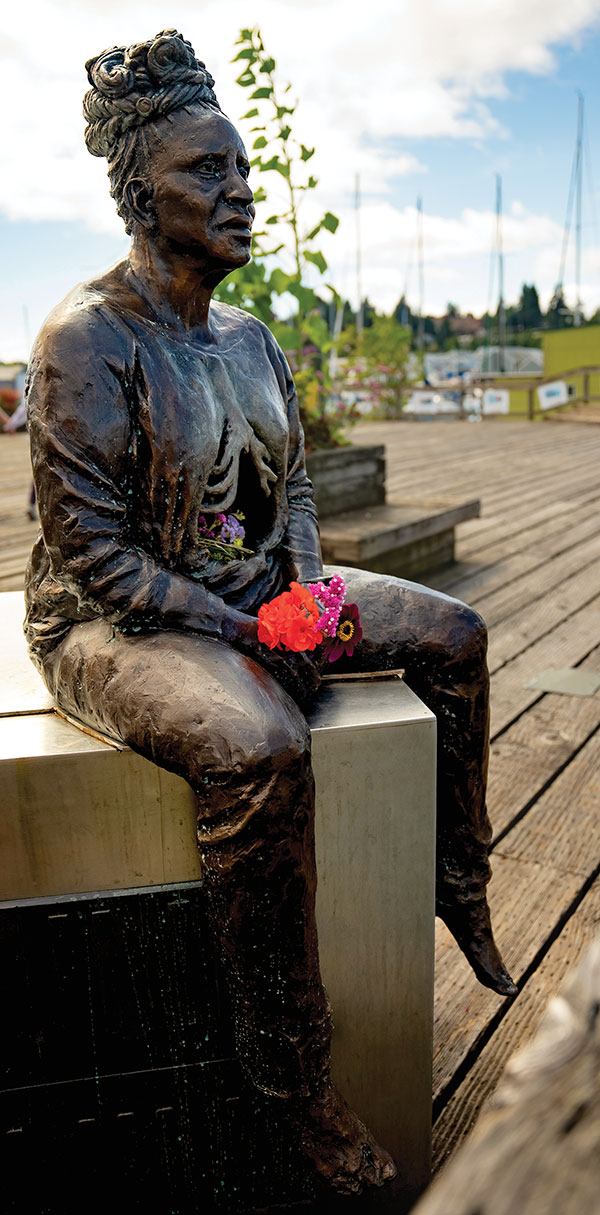 7 Woman with Graves at Her Back (right side view), cast bronze, flowers. Photo: Misael Martínez.