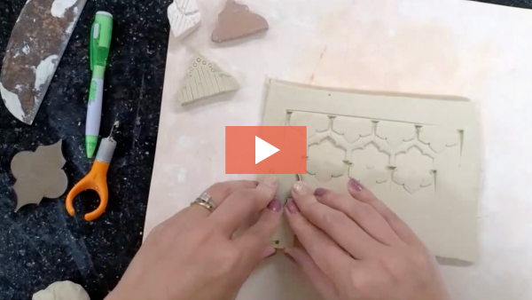 photo of Lindsay Scypta stamping an ornate homemade tool into a clay surface