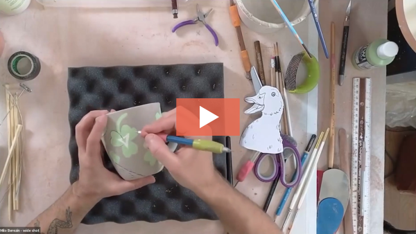 Image of Milo Berezin carving into an illustrated clay surface.