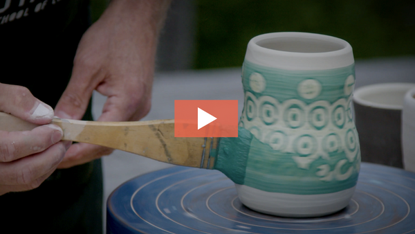 Paul Wisotzky paints underglaze over a wax-resist, sponge-stamp pattern
