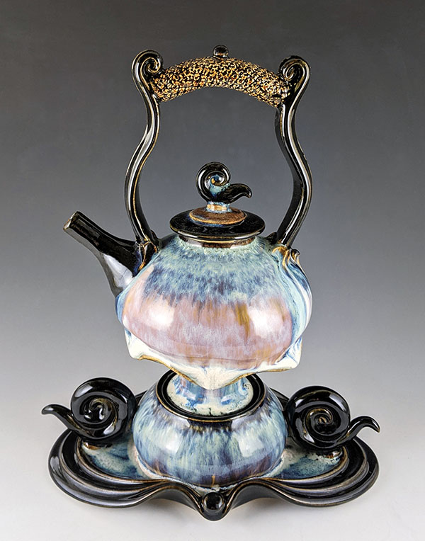15 Steve Loucks’ bluish and opal round teapot with amber overhead handle, 12 in. (30 cm) in height, stoneware, fired to cone 6 in an electric kiln. 