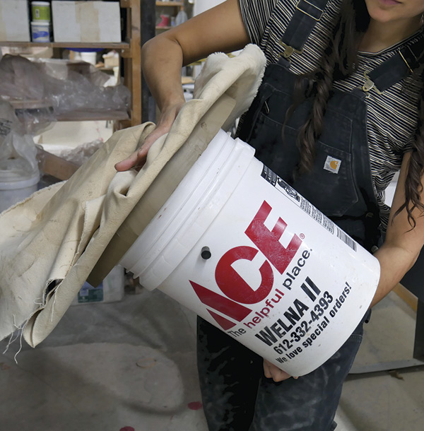 2 Support and press the slab into the bucket lip while flipping, so as to not disturb the clay’s memory.