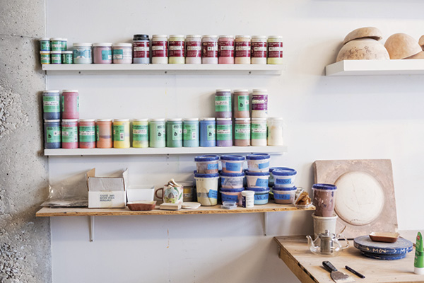 Glazes on wall shelves in Molly Anne Bishop's studio.