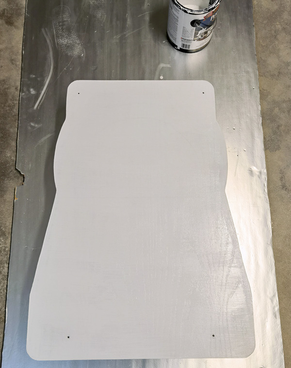 2 Drill mounting holes into the cut plywood and paint with a moisture-resistant paint to seal.