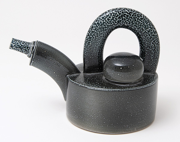 9 Walter Keeler's Teapot with Oval Extruded Spout & Handle, 8½ in. (22 cm) in width, stoneware, black stain, salt glaze, oil fired to cone 6–10, 2017. Photo: Goldmark Gallery.
