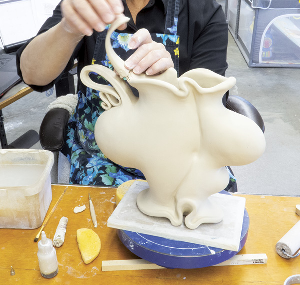 3 Attach so that a handle reaches outward, extending the top rim into space. As I work, I consider how these handles will be visually connected through slip trailing and glazes.