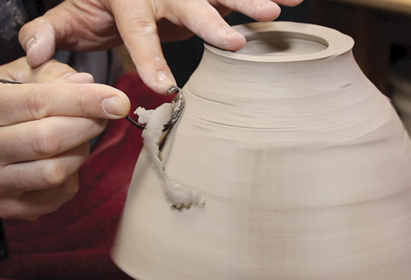 5 After the bowl has dried to a soft leather hard, trim the excess clay off the bottom half of the bowl. To protect the rim, I recommend using a leather-hard chuck.
