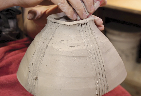 7 After trimming and carving the vertical lines, gently pinch four corners in the foot ring to mimic the shape of the rim. Refine the carved foot ring with a silicone rib.