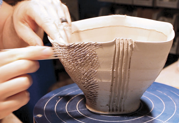 8 Using a large scoring tool, score the left and right sides of the bowl where the clay wedge will attach.