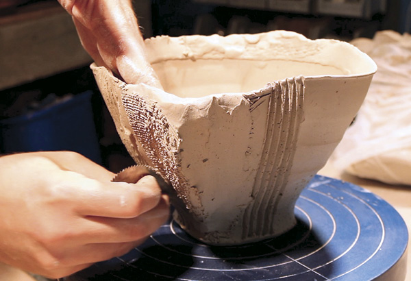 11 Using a small-toothed metal rib, scratch the exterior surface to smooth out the addition of the wedge of clay to the side of the bowl. Finish smoothing with a metal rib.