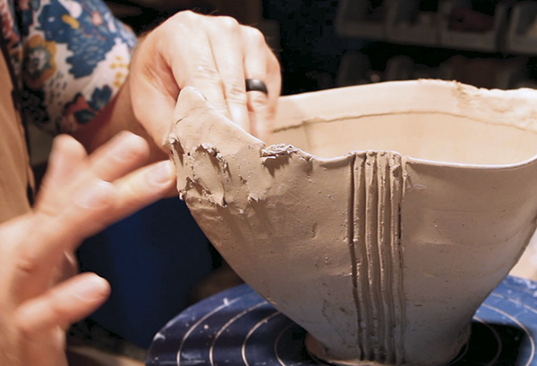 17 Begin adding small amounts of clay to the wedge and reinforced rim. This will become the neck of the finial head.