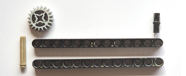 1 To assemble the tool, connect the liftarms with the longer pin (part 6558) and place the gear on it. Now, just push the shorter pin (part 2780) into the opposite hole of the liftarms for stabilization.