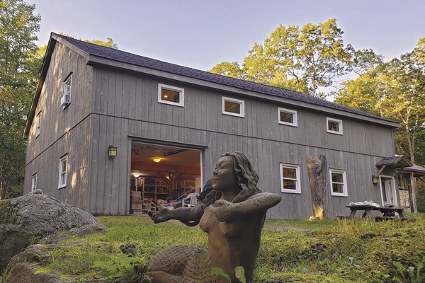 3 A front view of the studio with the garage door open on to the first floor. An old mermaid sculpture made by Palmer keeps watch.