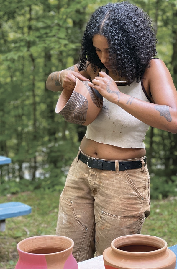 9 Addis Alemu decorating pots outside the communal ceramics studio. Photo: Hambidge Center staff.