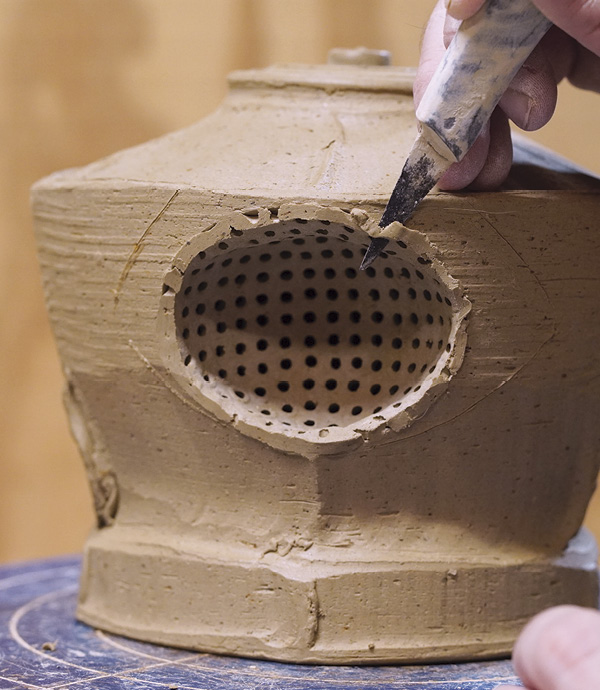 11 Install strainer and trim and blend excess clay.