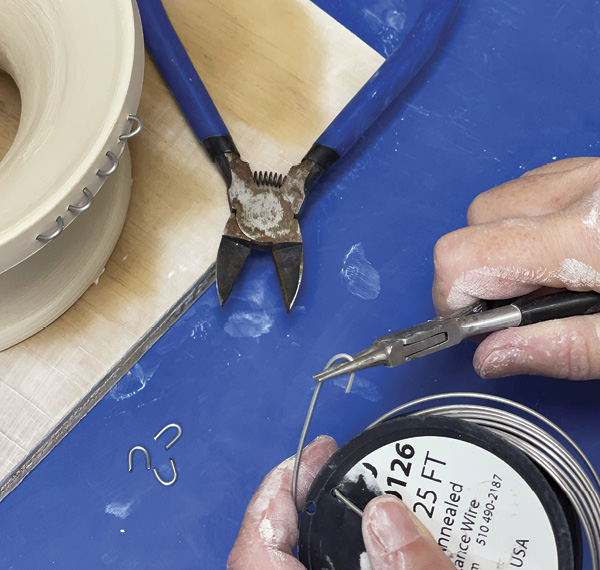 2 Using round-nose pliers, fashion U-shaped pins to surround the rim of the tree.