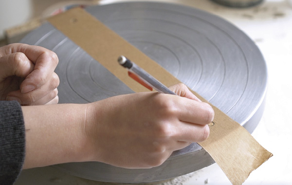 1 Use tape as a template to measure the exact distance between your pinholes.