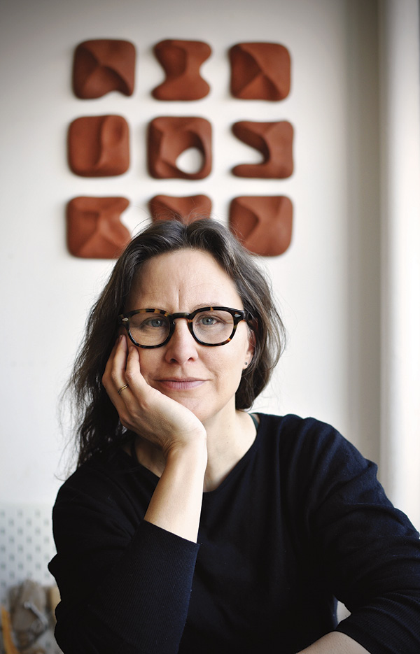 2 Janice Cormier sitting in front of her wall piece, A Memory of Tides no 03. Photo: Ives Levesque.