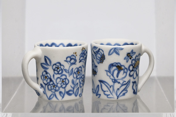 5 Esther Mech’s Flowers And Bee Mini Mugs, 3¾ in. (9.5 cm) in height, porcelain, underglaze, gold luster. Photo: Courtesy of The Clay Studio.