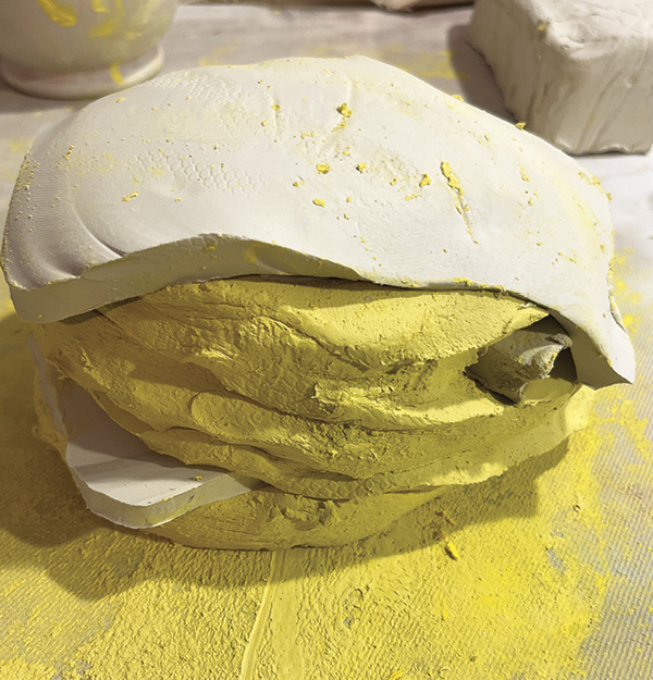 5 Combine the stained clay with the remaining clay by slap wedging, layering cross-sections then cutting the stack in half, slamming together, and repeating until blended.