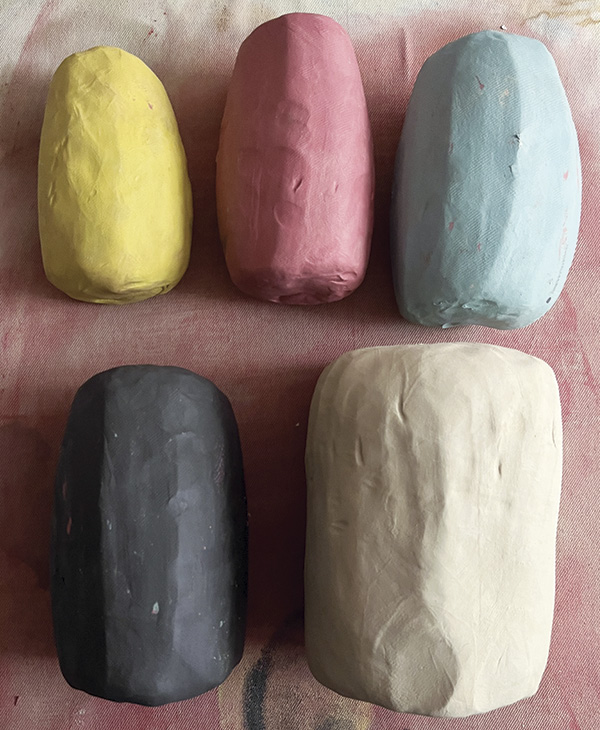 7 Stain a variety of colored porcelains of a relatively similar size alongside a larger ball of unstained porcelain.