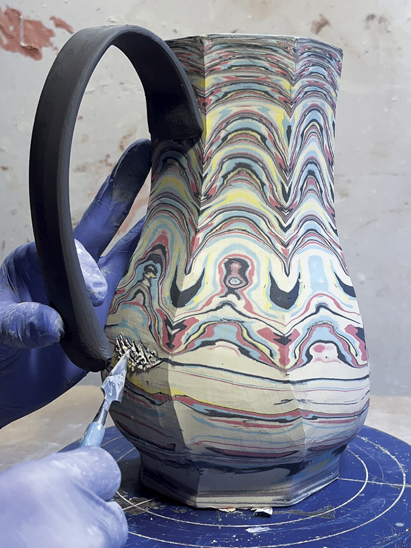 23 To avoid cleanup, trace the footprint of the handle. Only score and slip inside the lines. Score, slip, and attach the bottom of the handle.
