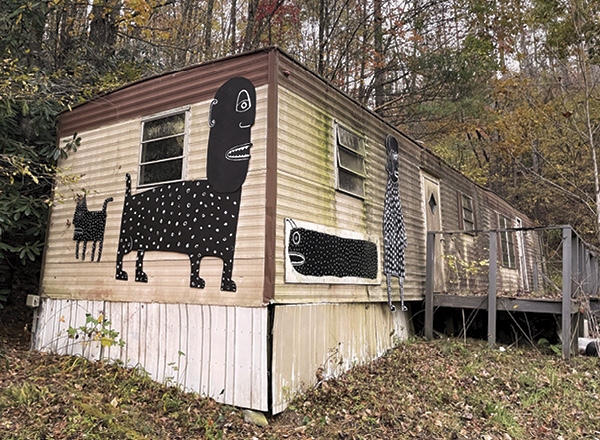 Plywood creatures wrap around an abandoned trailer home near Anderson’s home.
