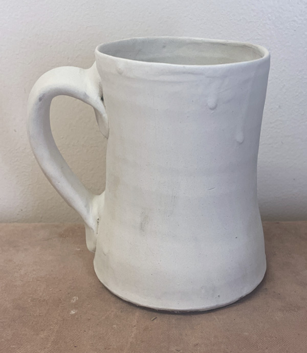 8 Apply two coats of white slip to leather-hard mug with paintbrush.