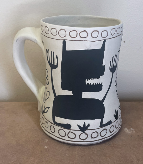10 Apply two coats of black underglaze to create character silhouette and add additional decorative elements.