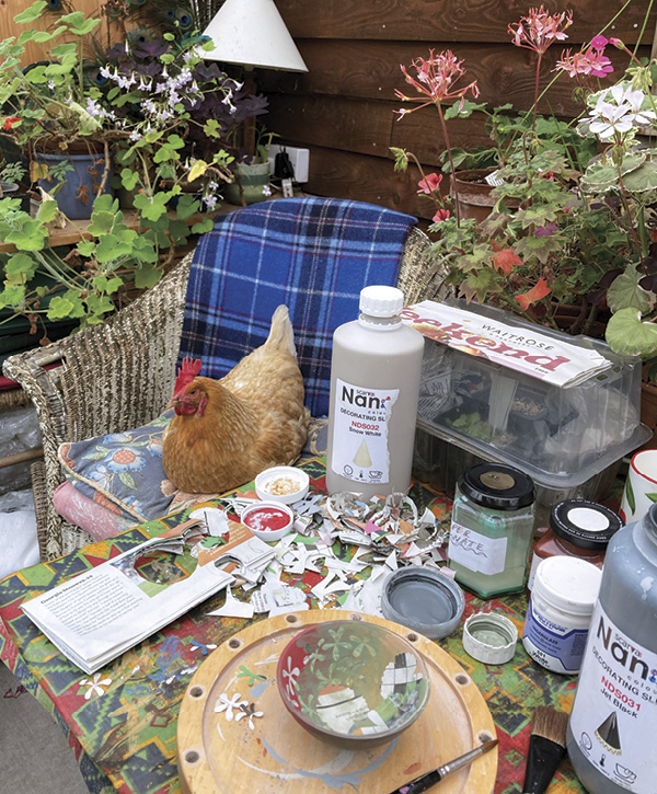11 When the weather is pleasant, Sampson’s studio activities spill outside; her chicken, Janus, looks on while she decorates a bowl.