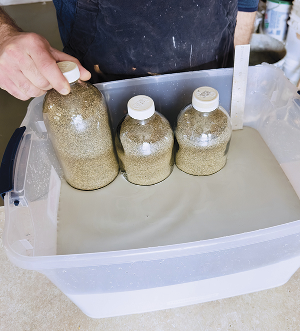 1 Add sand-filled bottles into the tub of glaze to displace its volume.