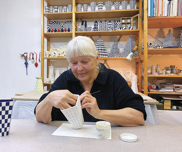 15 Ridderikhoff in the studio, decorating a vase with wax resist.