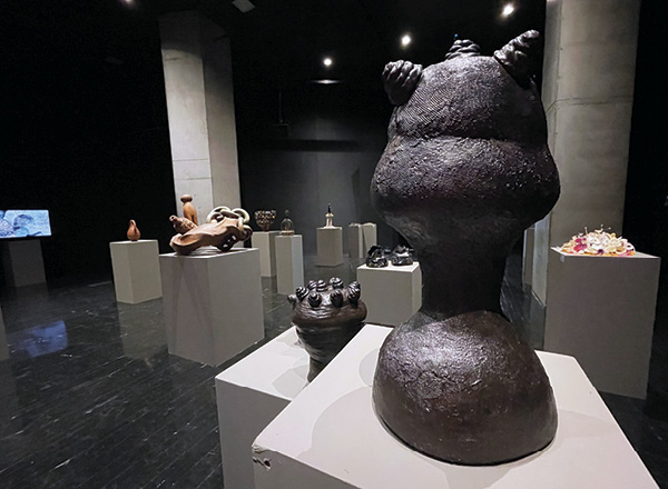 6 Foreground: Lola Ayisha Ogbara’s Untitled (from the Black Pot Calls the Kettle series), 111/4 in. (29 cm), stoneware with glaze, 2022. Installation view of Clay Holds Water, Water Hold Memory. Photos: Heidi McKenzie.
